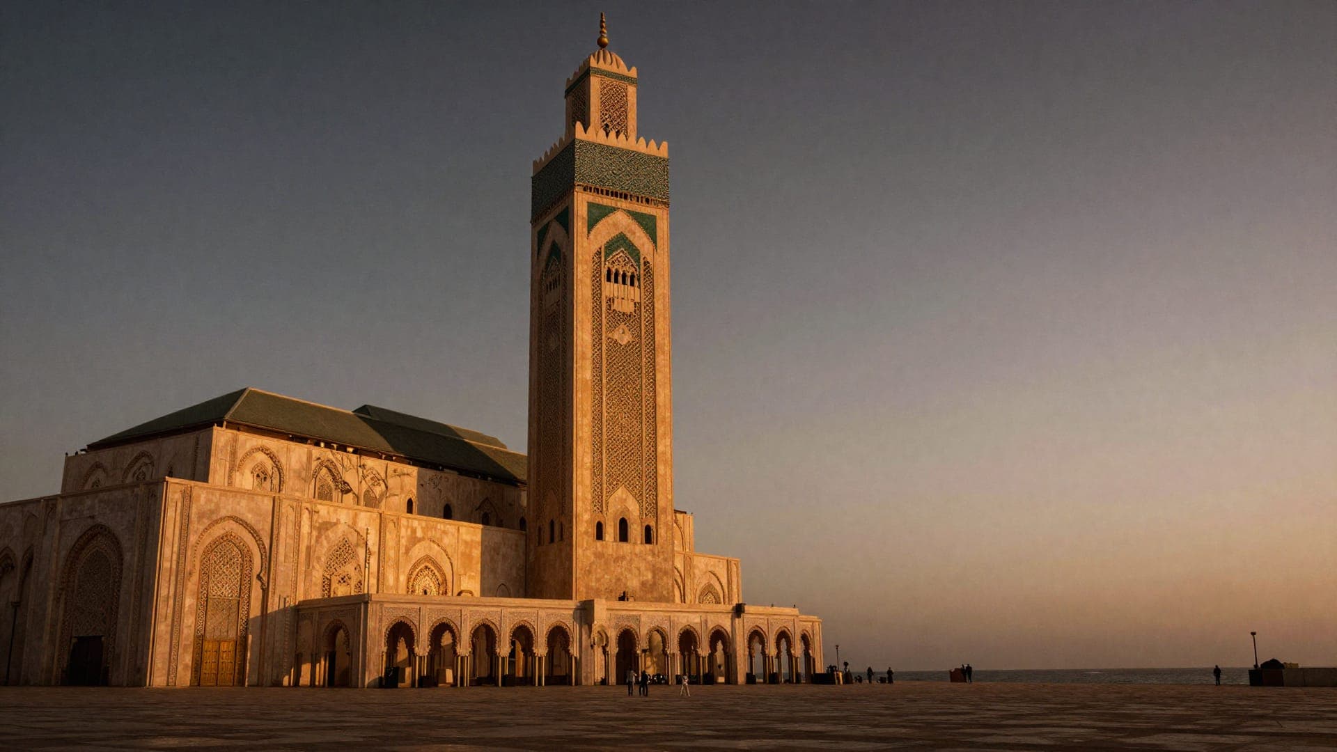 The Hassan II Mosque in late afternoon light, its minaret standing over an almost empty stone esplanade that runs out to the Atlantic.